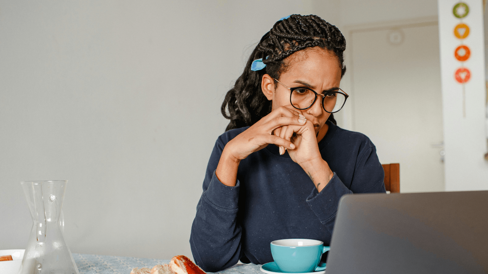 Woman looking at Laptop with the EWG Tap Water Database search results placed on a home kitchen counter